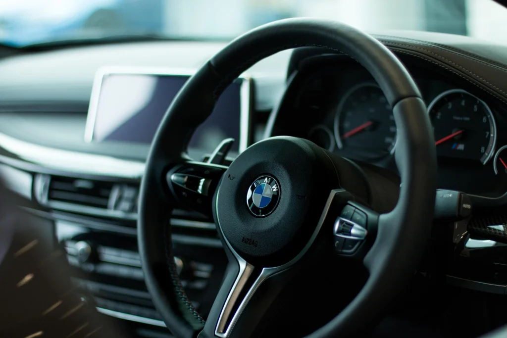 Close-up of a BMW steering wheel, representing luxury and professional corporate travel.