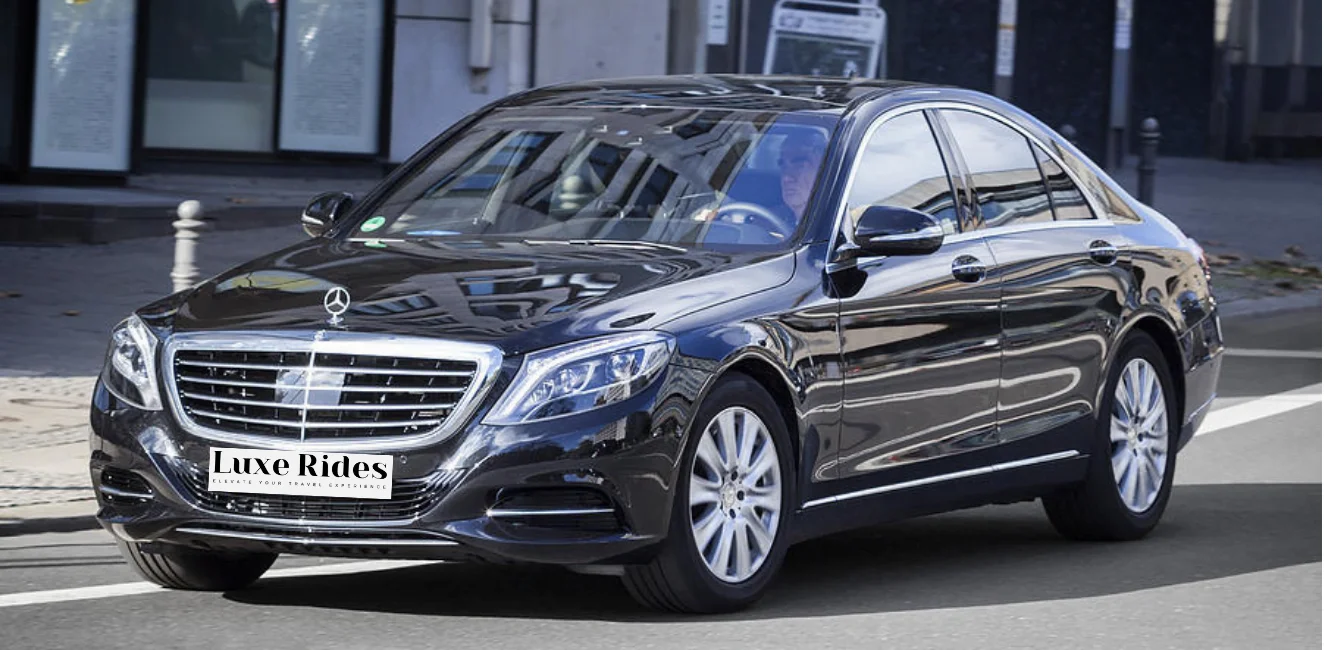A sleek black Mercedes-Benz S-Class from LuxeRides, driving through the streets of London, showcasing luxury and sophistication.
