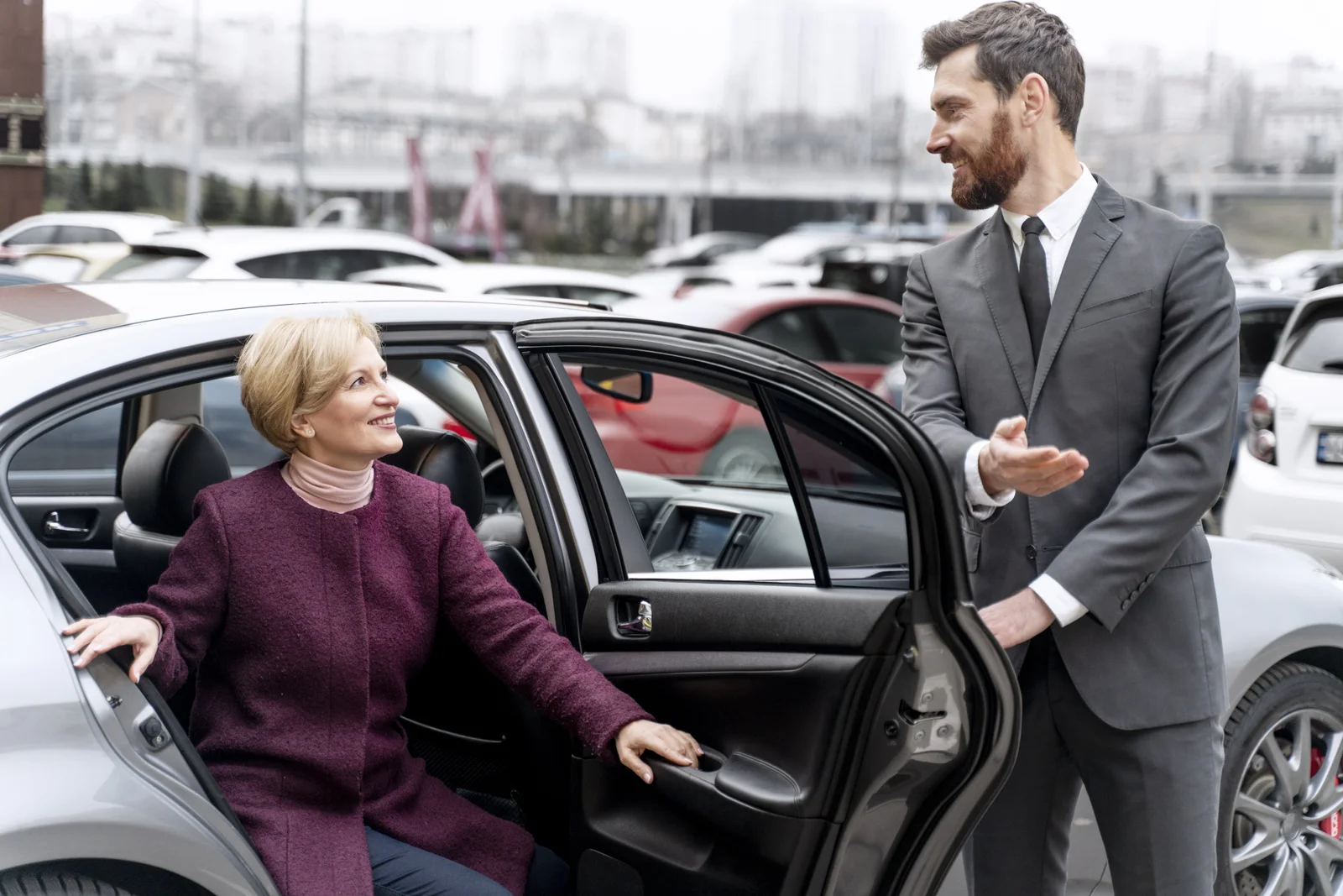 LuxeRides professional chauffeur assisting a client with luxury airport transfer service in London.
