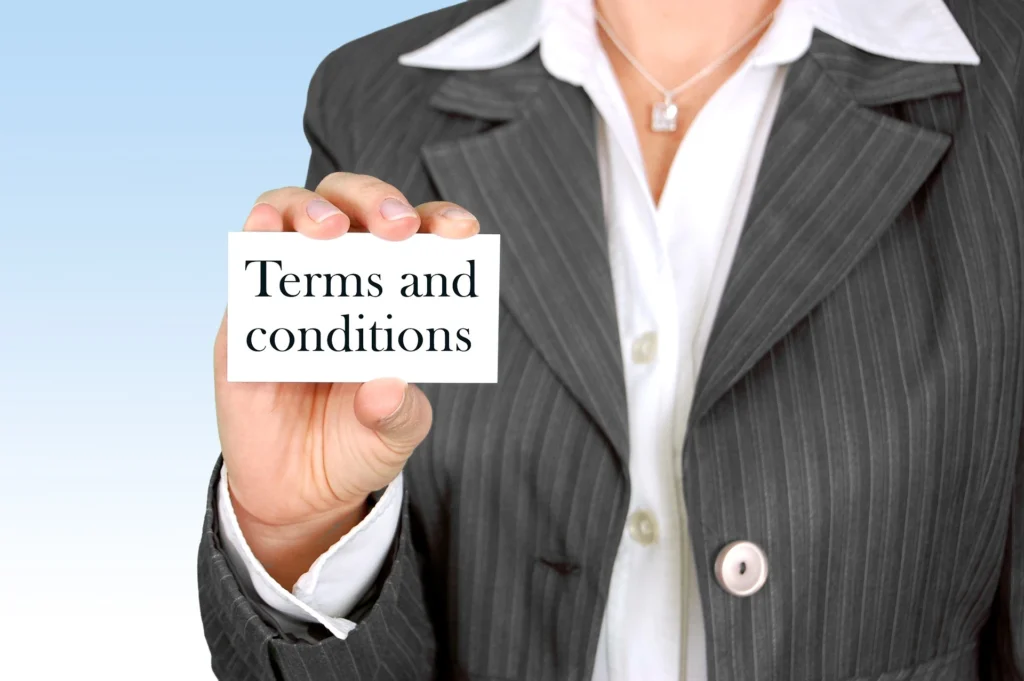 Businesswoman holding a card with "Terms and Conditions" written on it.