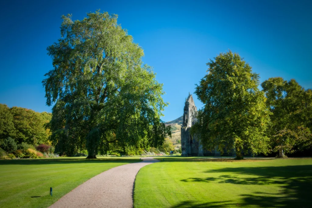 Lush garden near historic ruins in Edinburgh, ideal setting for chauffeur service travel